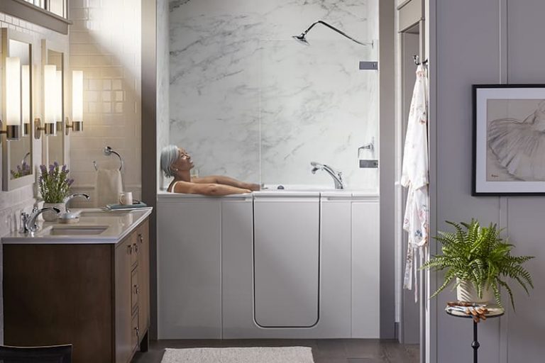 Walk-in tub with door entry in a marble-look surround